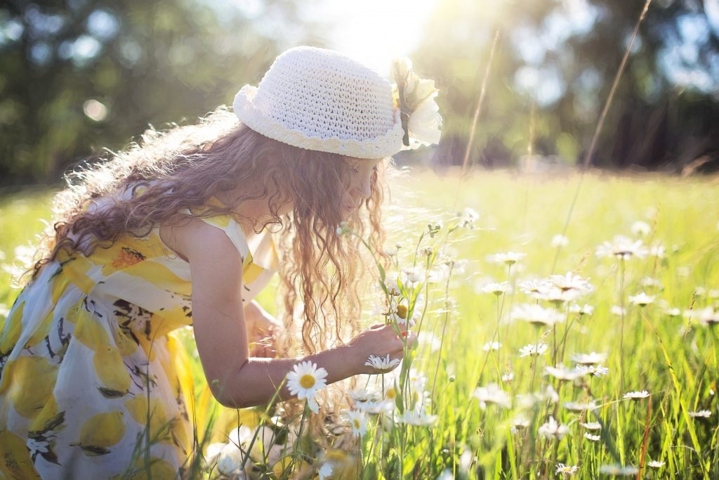 Niña oliendo flores en primavera.